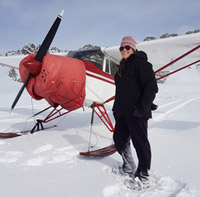 Michelle standing beside aircraft in snow