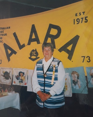 alara member in front of banner